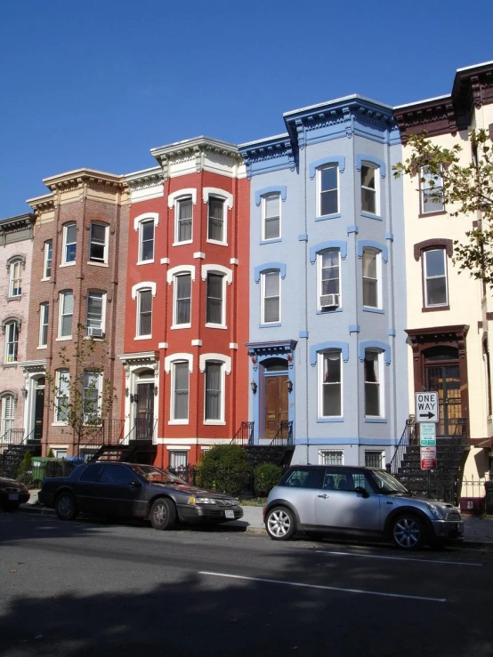 a parking lot in front of row houses with different colored buildings