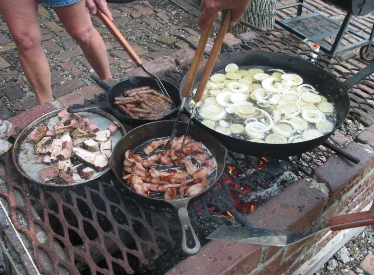 people in street cooking on the grill outdoors