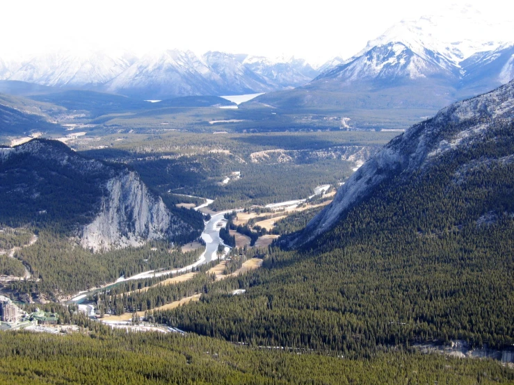 a view of mountains, trees, rivers and valley from a lookout point