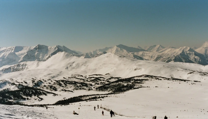 a group of people skiing on a mountain covered in snow