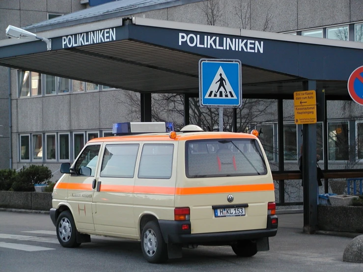 an orange and white van is parked by a building