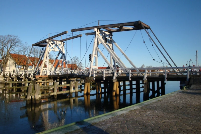 two white cranes sit at the end of a bridge