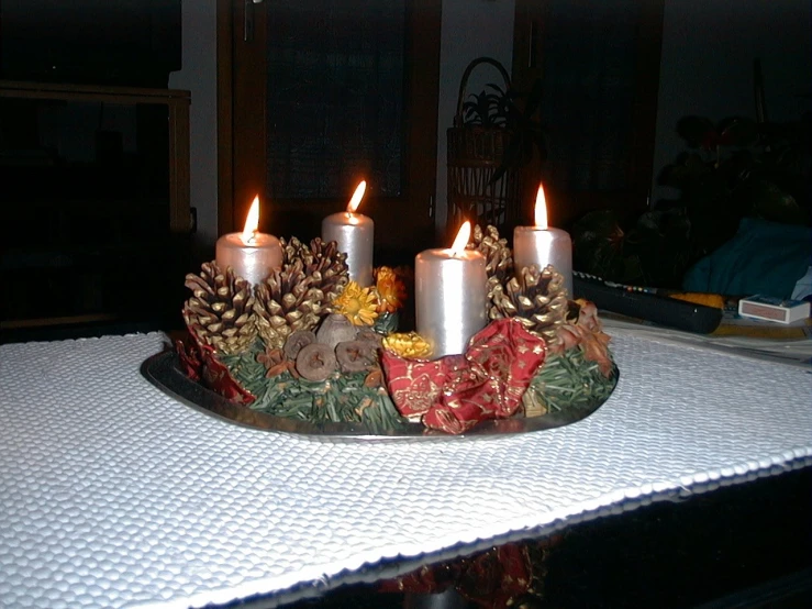 candles are sitting on top of a tray covered in christmas decorations