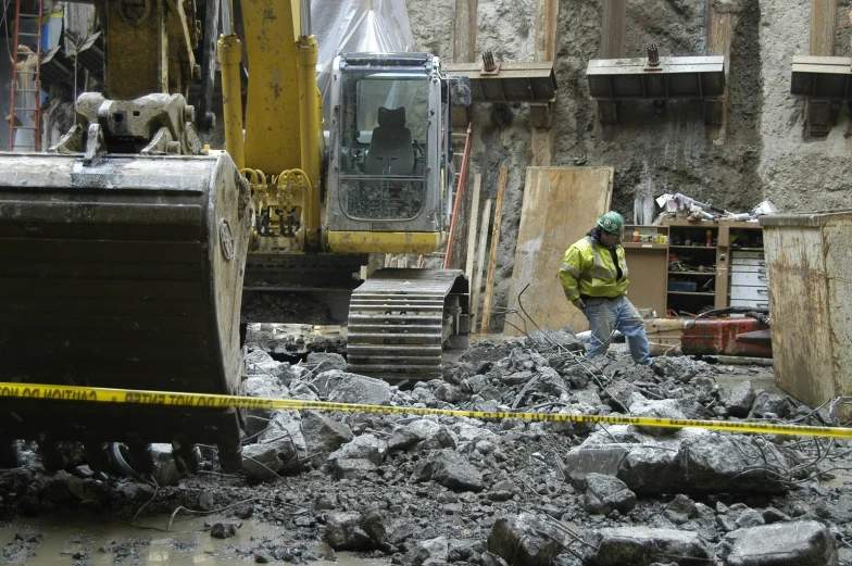 a man in yellow jacket walking next to buildings