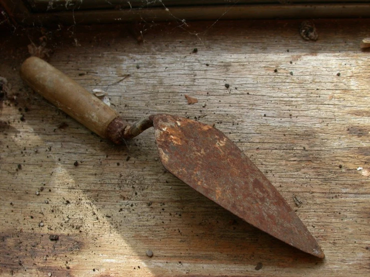 a rusted up knife on a piece of wood