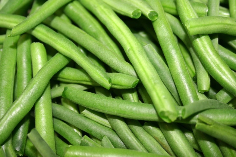a large pile of green beans with a blurry background