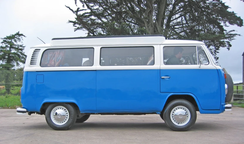 an old blue and white van with people inside in the back