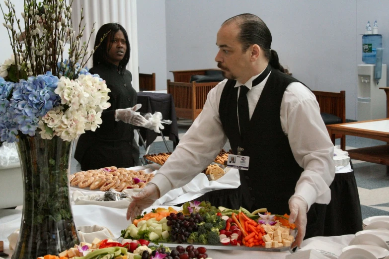 a waitress placing a serving platter of food in front of the diner