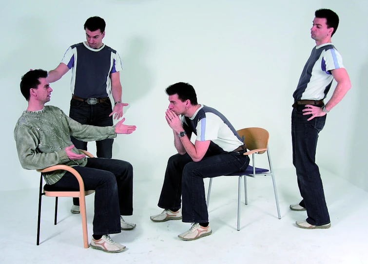 four men in grey shirts standing and sitting