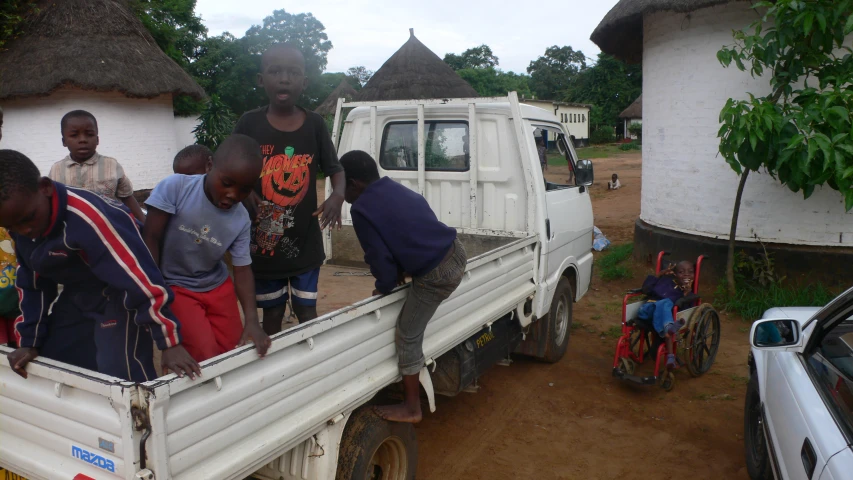 many people standing in the back of a truck with a white truck