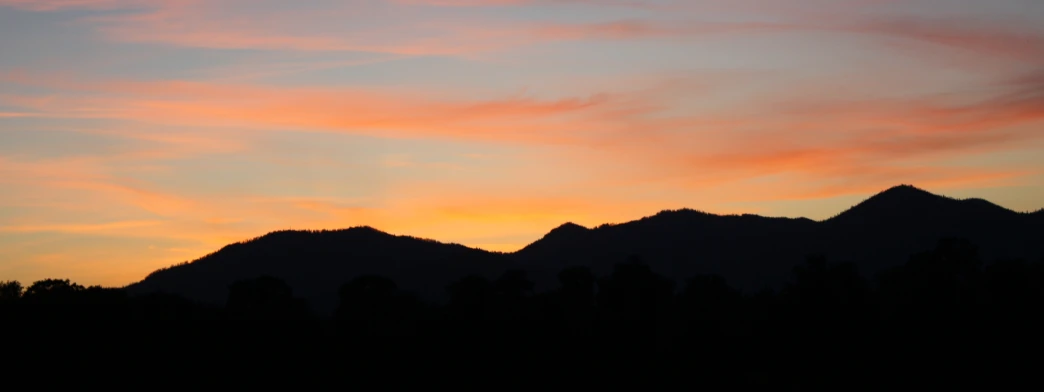 the sun is setting behind some mountains