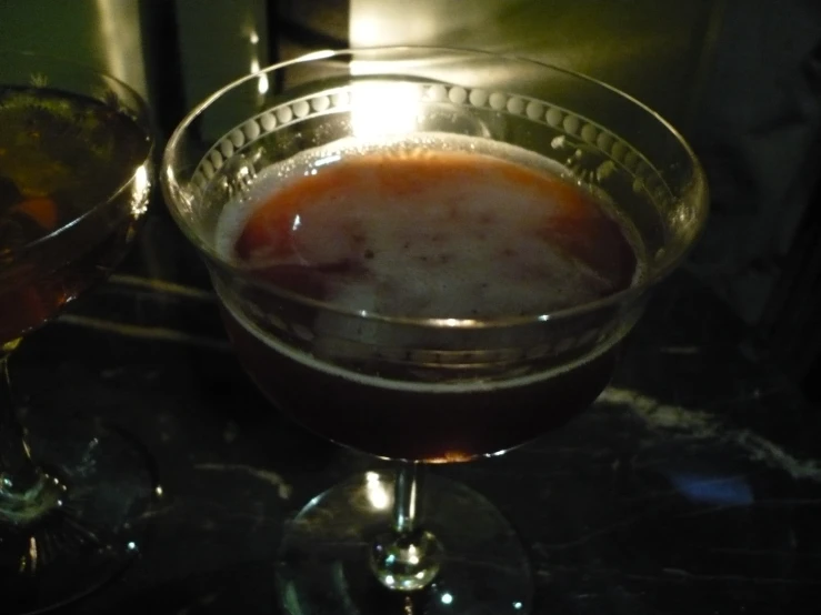 glasses of liquid on a counter with a light shining from behind