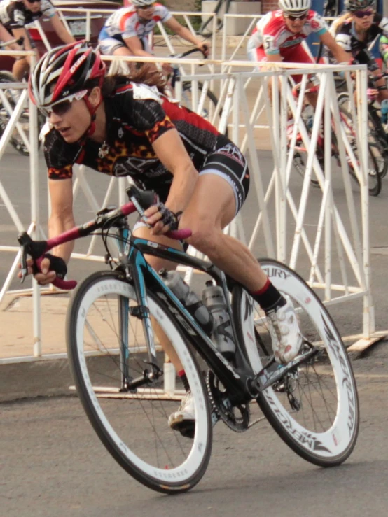 a man riding a bicycle down a street with spectators in the background