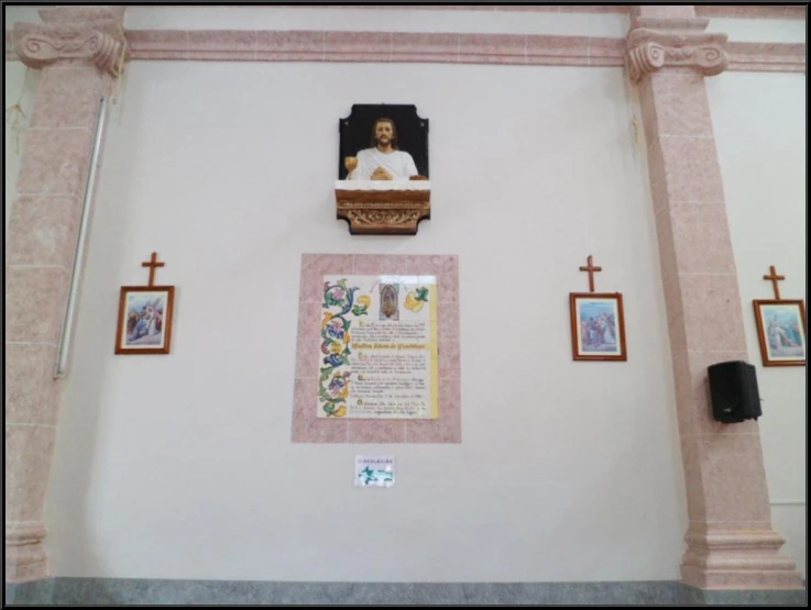 the wall of a church with many pictures and a plaque on it
