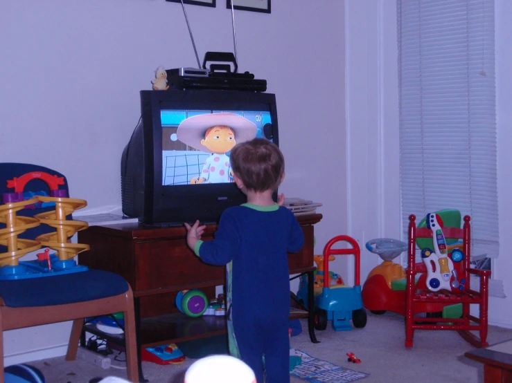 a small child with his hands on a television
