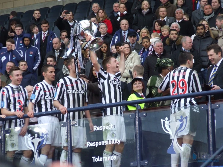 the referee is holding a trophy over his shoulder