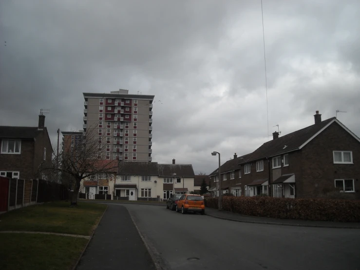 a car is driving down a road in front of some residential buildings