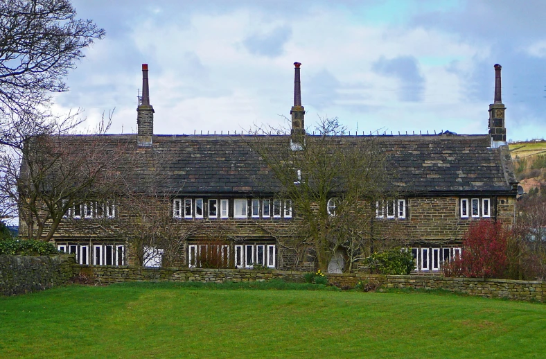 a large old house with three chimneys on top