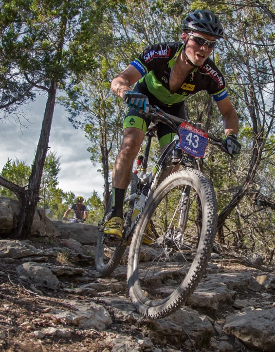 a man on a mountain bike rides through the trees