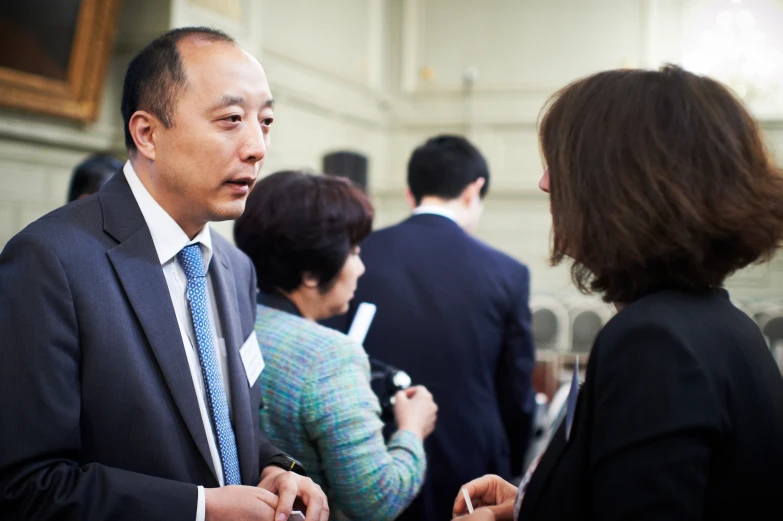 a man in a business suit standing at an event