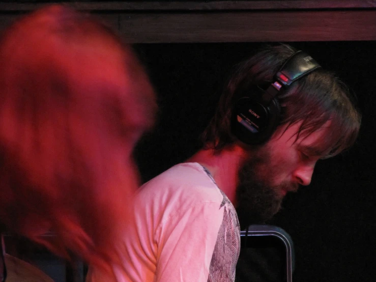 a person wearing headphones on top of a piano