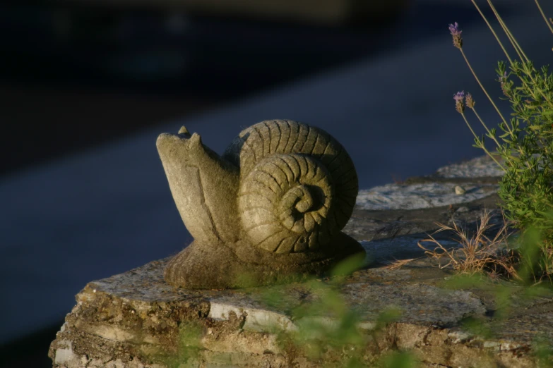 a small statue is sitting on a rock