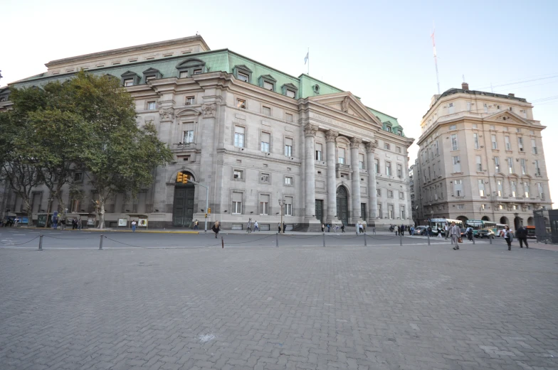 a large stone building with several people walking around