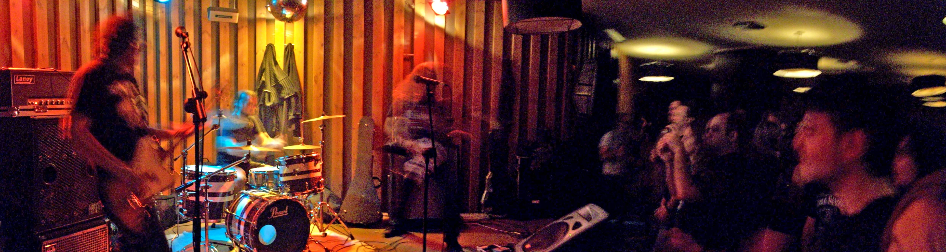 group of people standing around a living room with music instruments and lighting