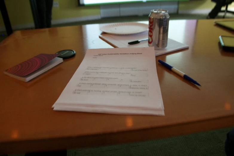 a table with some drinks, an empty drink can, and papers on it