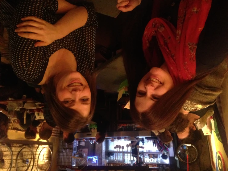 two ladies in a busy restaurant smile for the camera