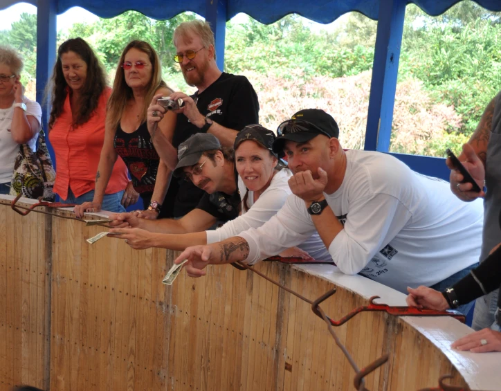 many people standing on a wooden platform together