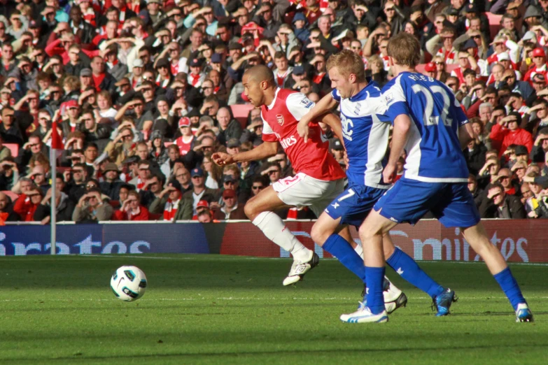 a couple of men playing soccer in front of a crowd