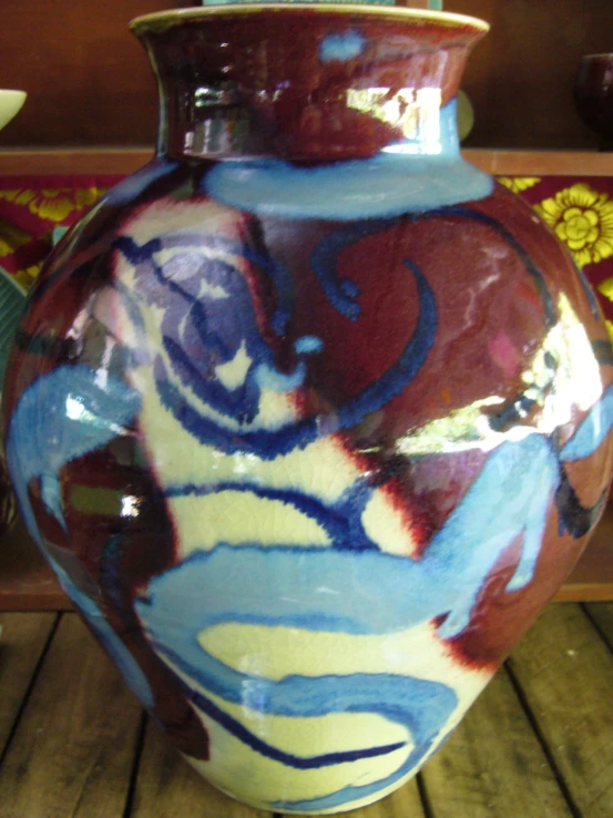 a ceramic vase sitting on a table next to flowers