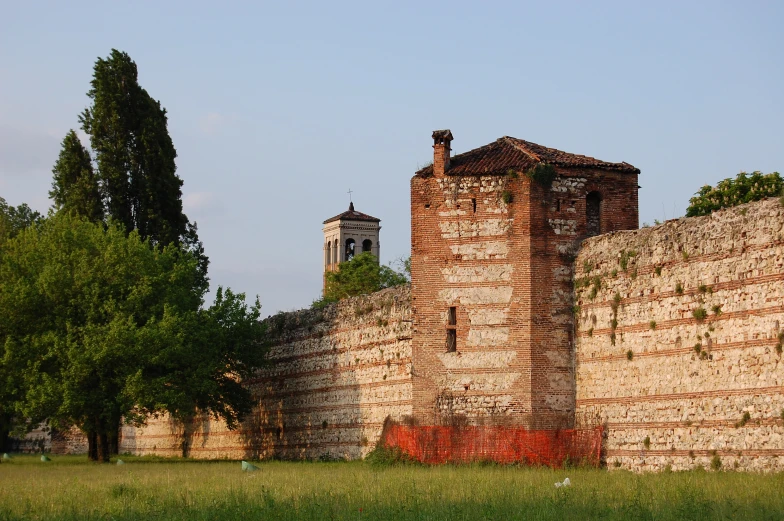 a very tall brick building sitting on top of a grass covered field