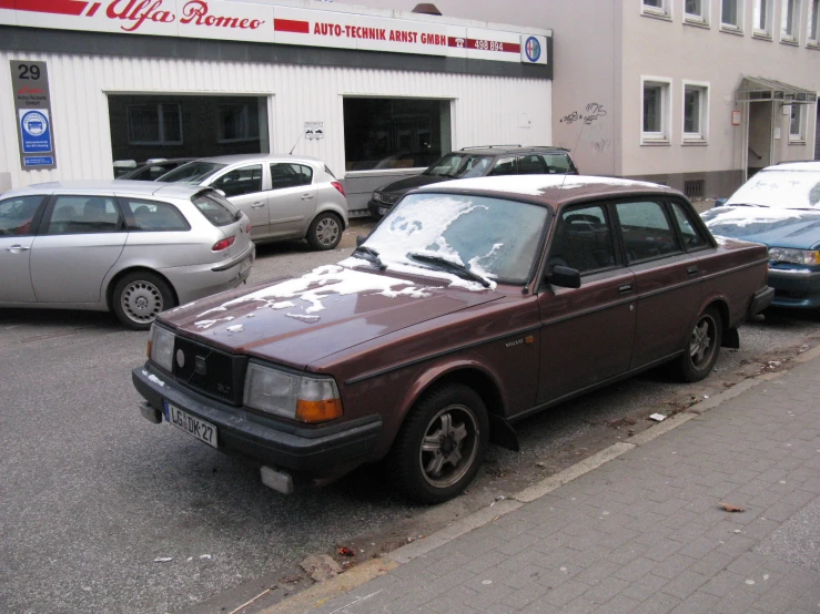 cars parked in the front of the building on the side of the road