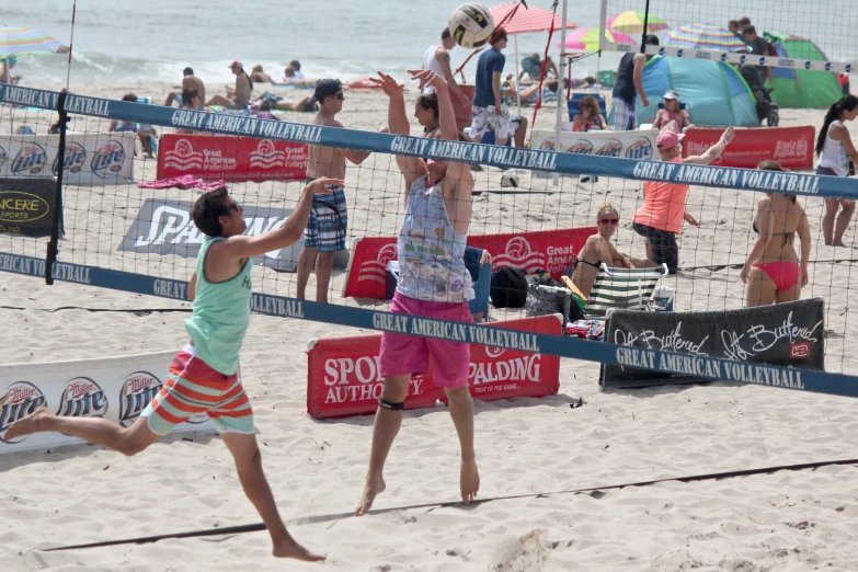 two girls are playing volleyball on the beach