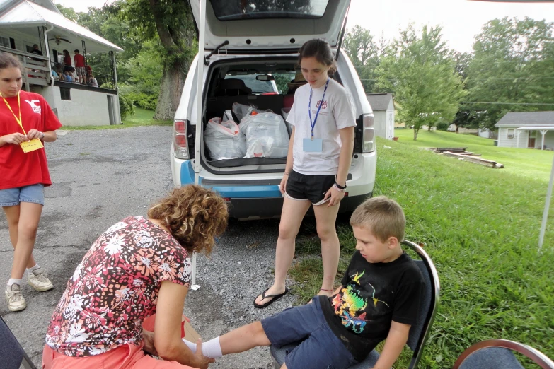 several people standing near the back of an mini van