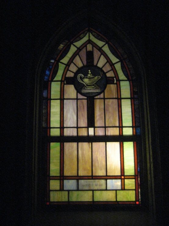 an old stained glass window with a dove on the cross