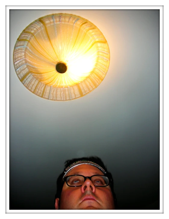 a man standing in front of a white light fixture