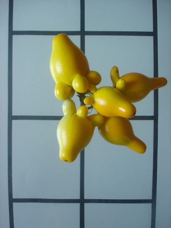 a bunch of yellow peppers hang from a hook