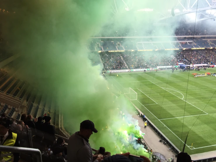 green smoke coming from a fire hydrant in front of a stadium