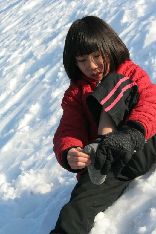 a girl sitting in the snow on top of snow