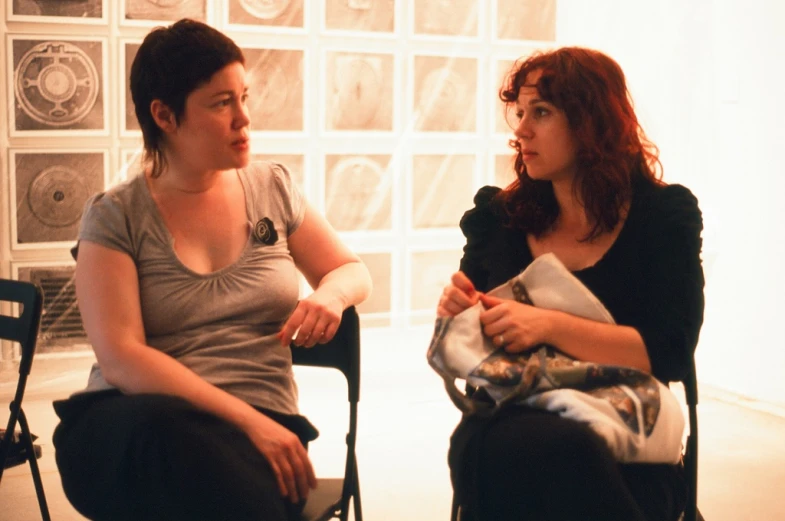 a couple of women sitting in chairs talking