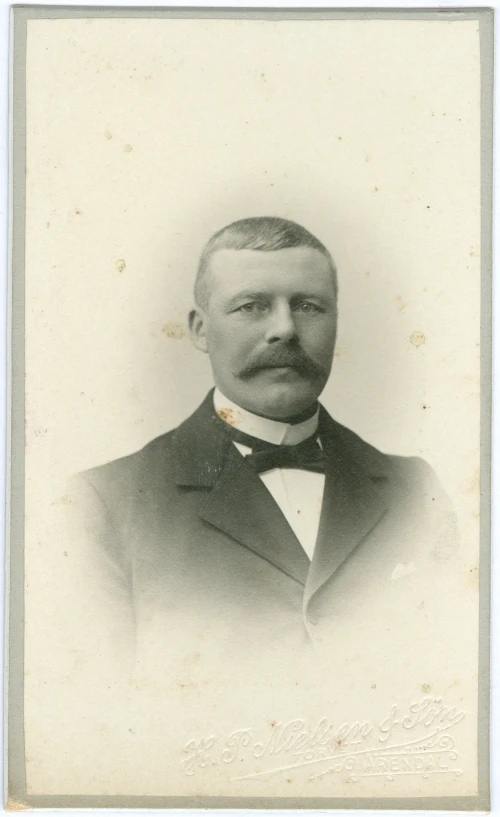 a portrait of a man wearing a suit and bow tie