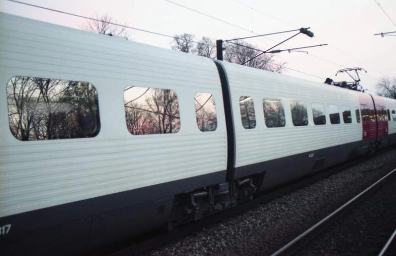 the train is on the tracks near a forest