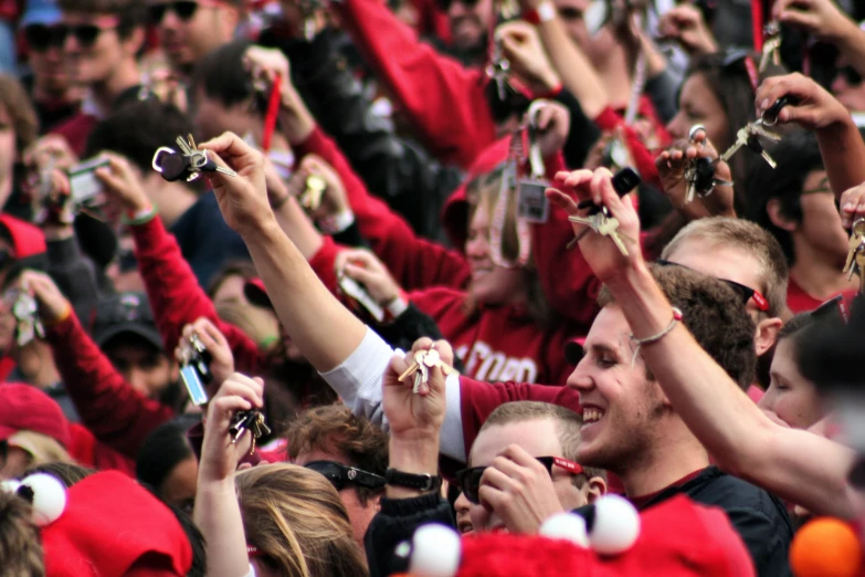 a group of people in a crowd take pictures with their cell phones