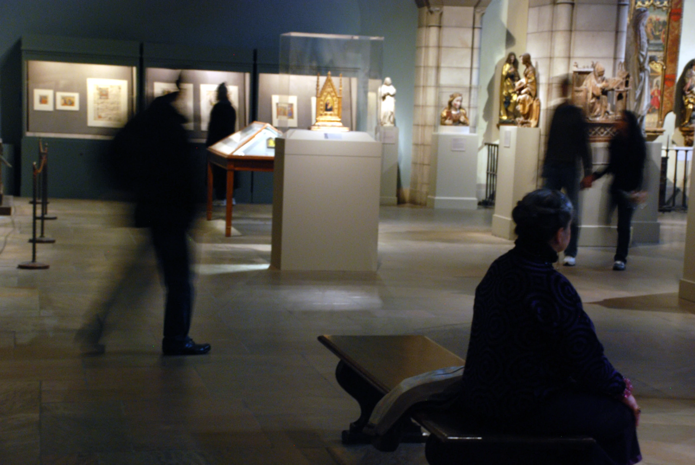 a woman sitting on a bench in a museum