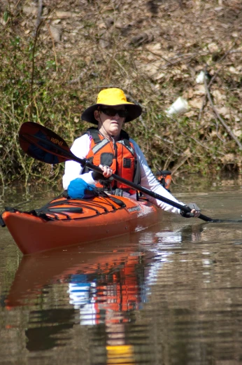 a person sitting in a boat with a yellow helmet