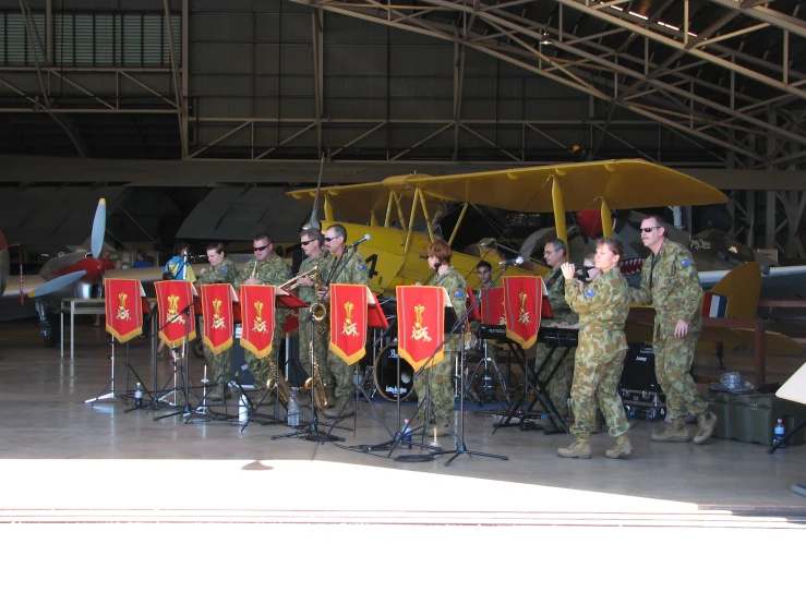 a group of military personnel standing around a plane