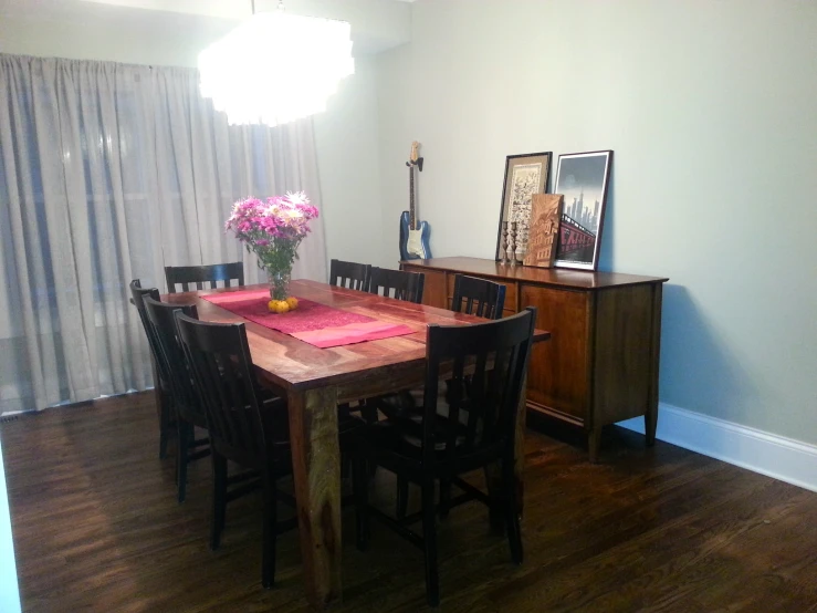 a dining room with a dining table, chairs and flowers on it